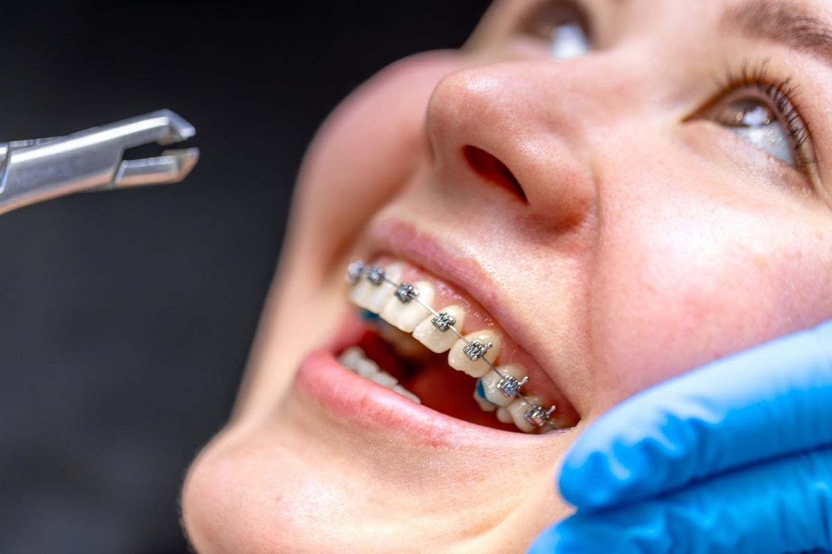 A woman wearing metal braces receives an adjustment